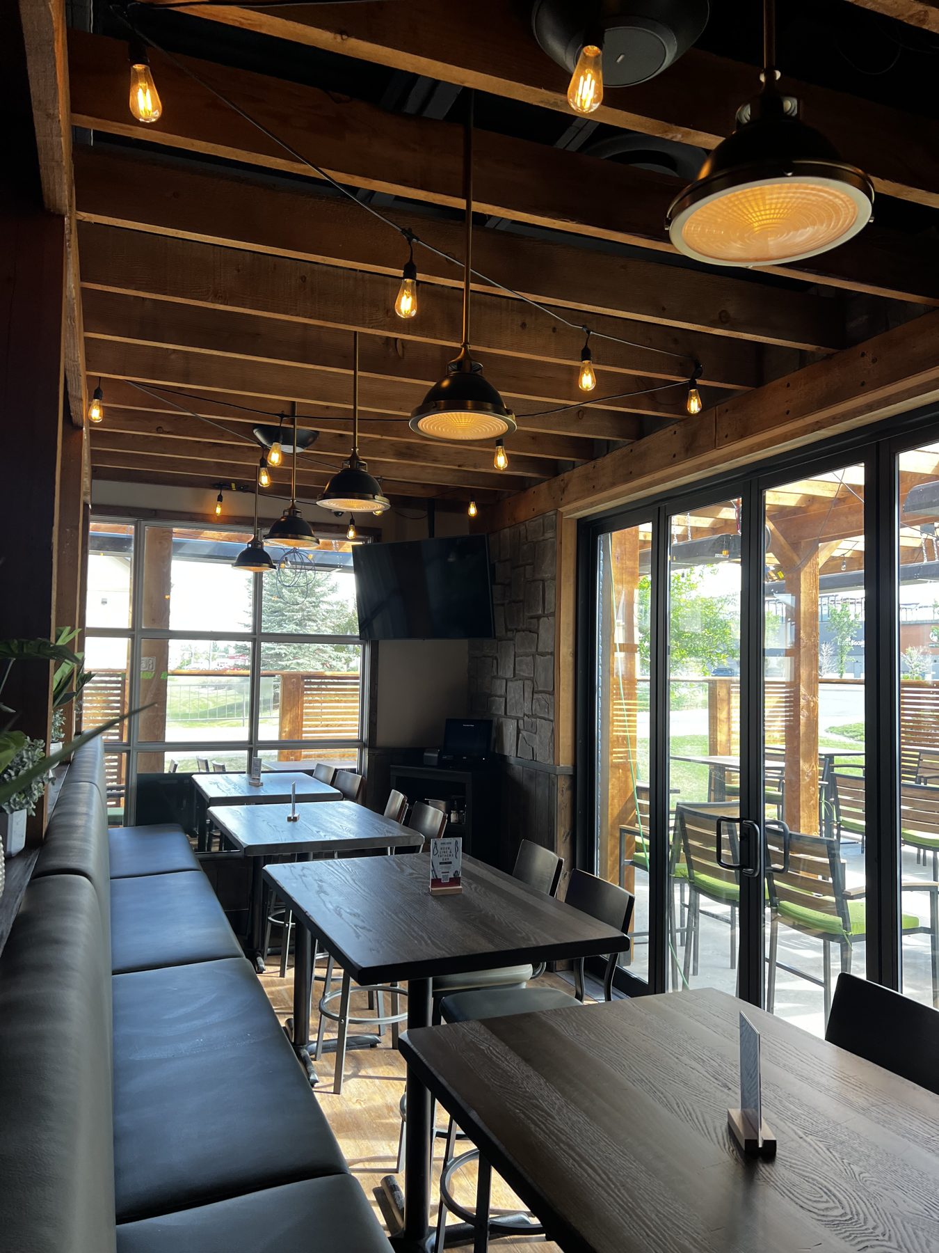Restaurant dining area with wood beams, stone walls, and pendant lighting — Blowers and Grafton (Shawnessy)