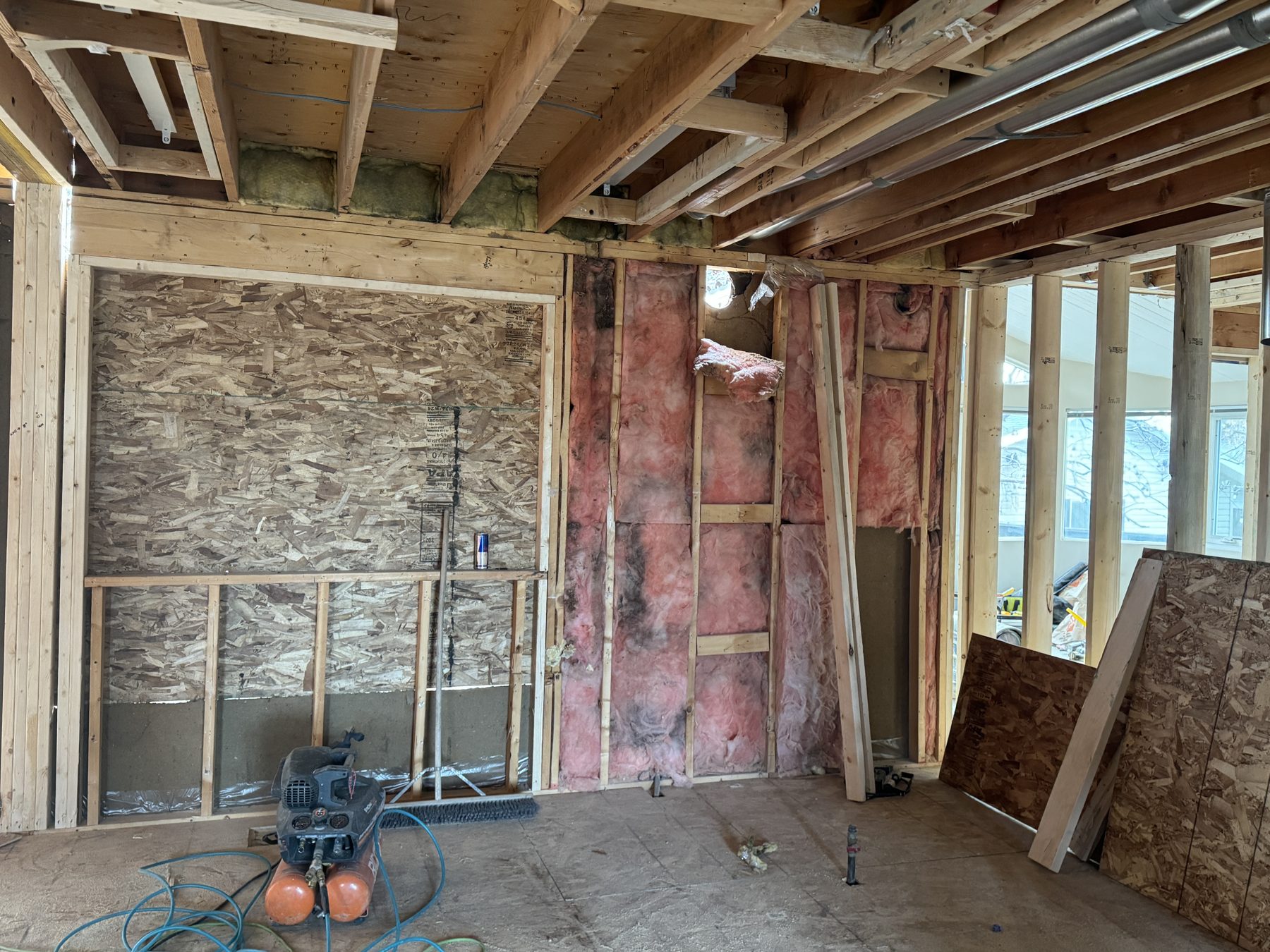 Construction interior with exposed studs, insulation, and unfinished walls — 188 Lake Adams Crescent SE, Calgary
