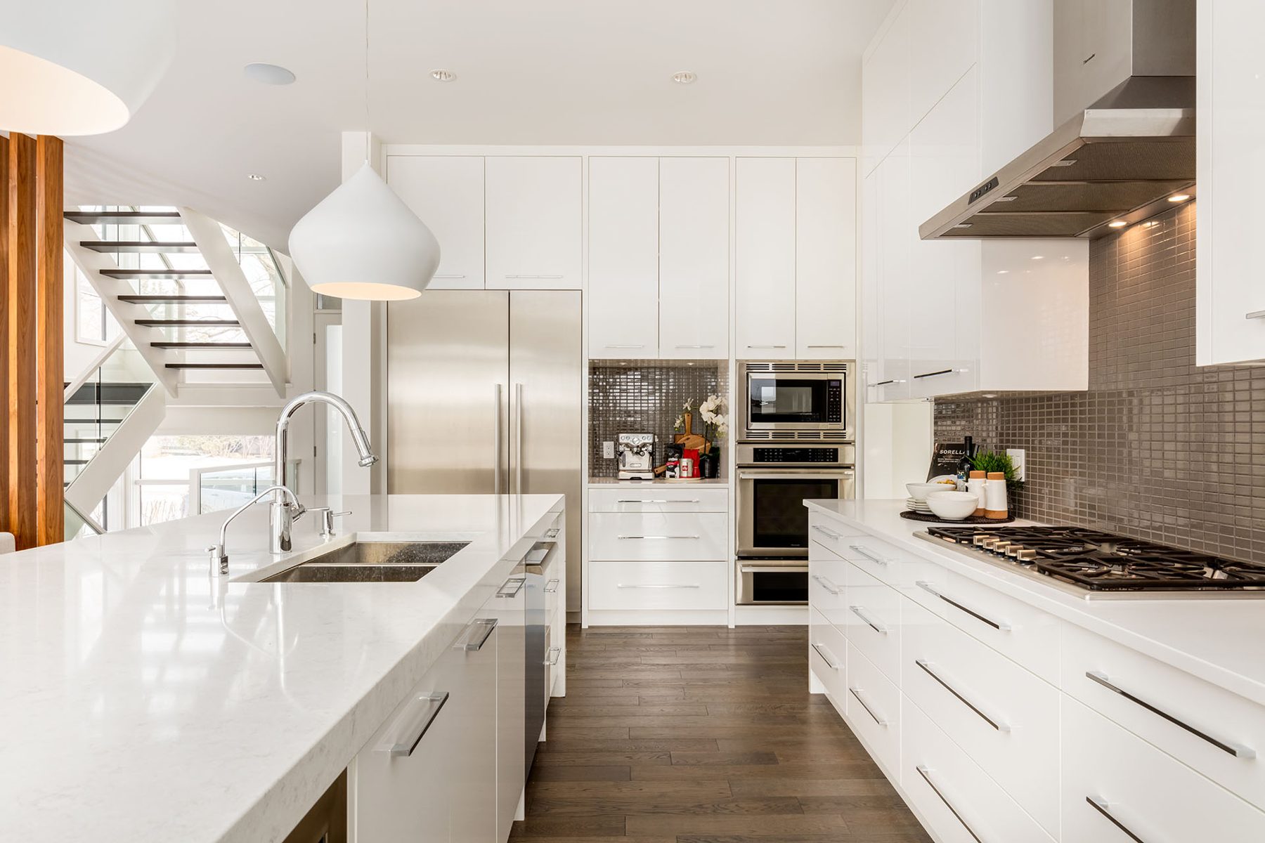 Modern white kitchen with quartz island and stainless steel appliances — Casa Blanca