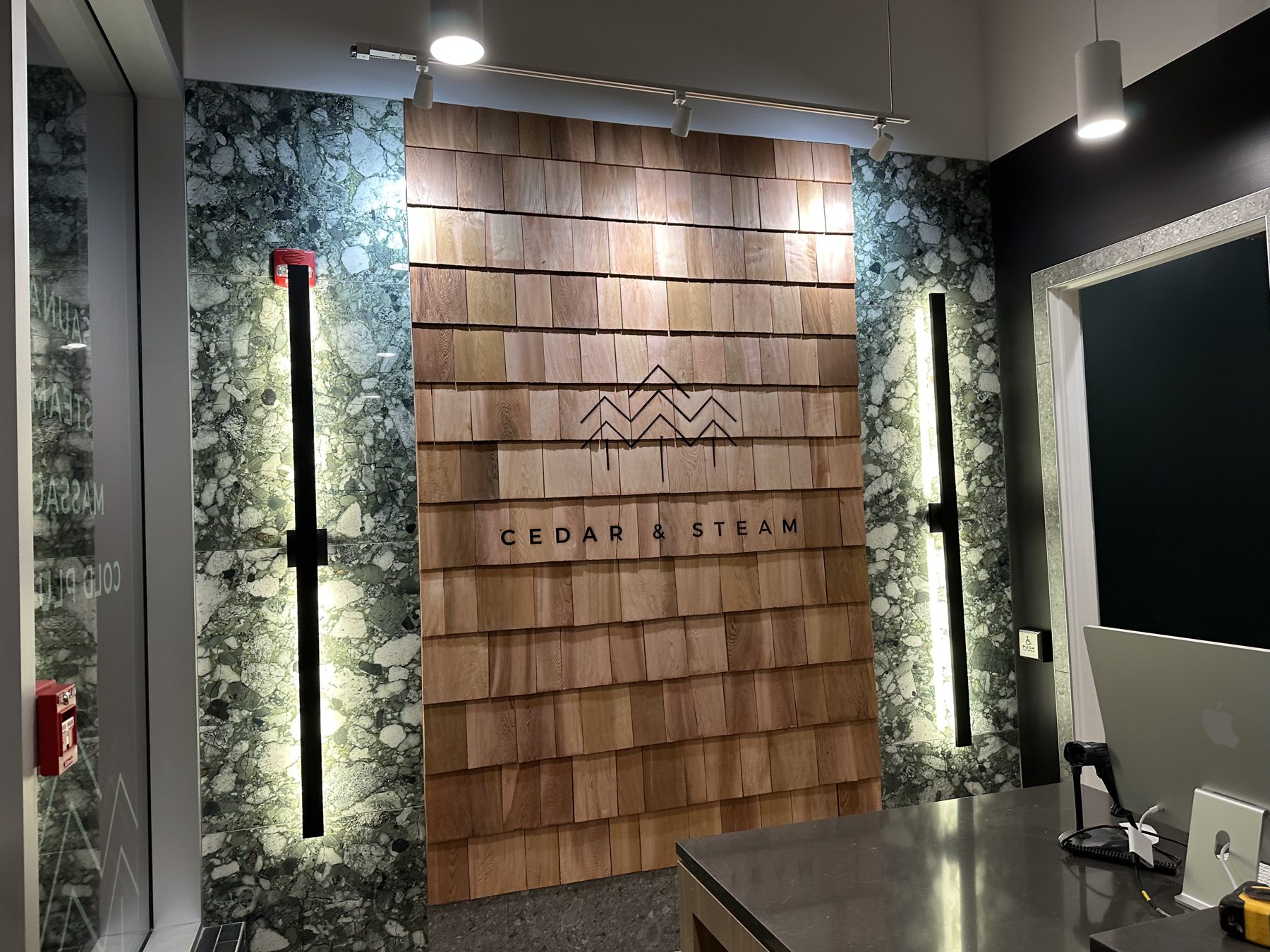 Cedar wood wall installation with marble accent and modern lighting — Cedar Steam and Spa (Trinity Hills)