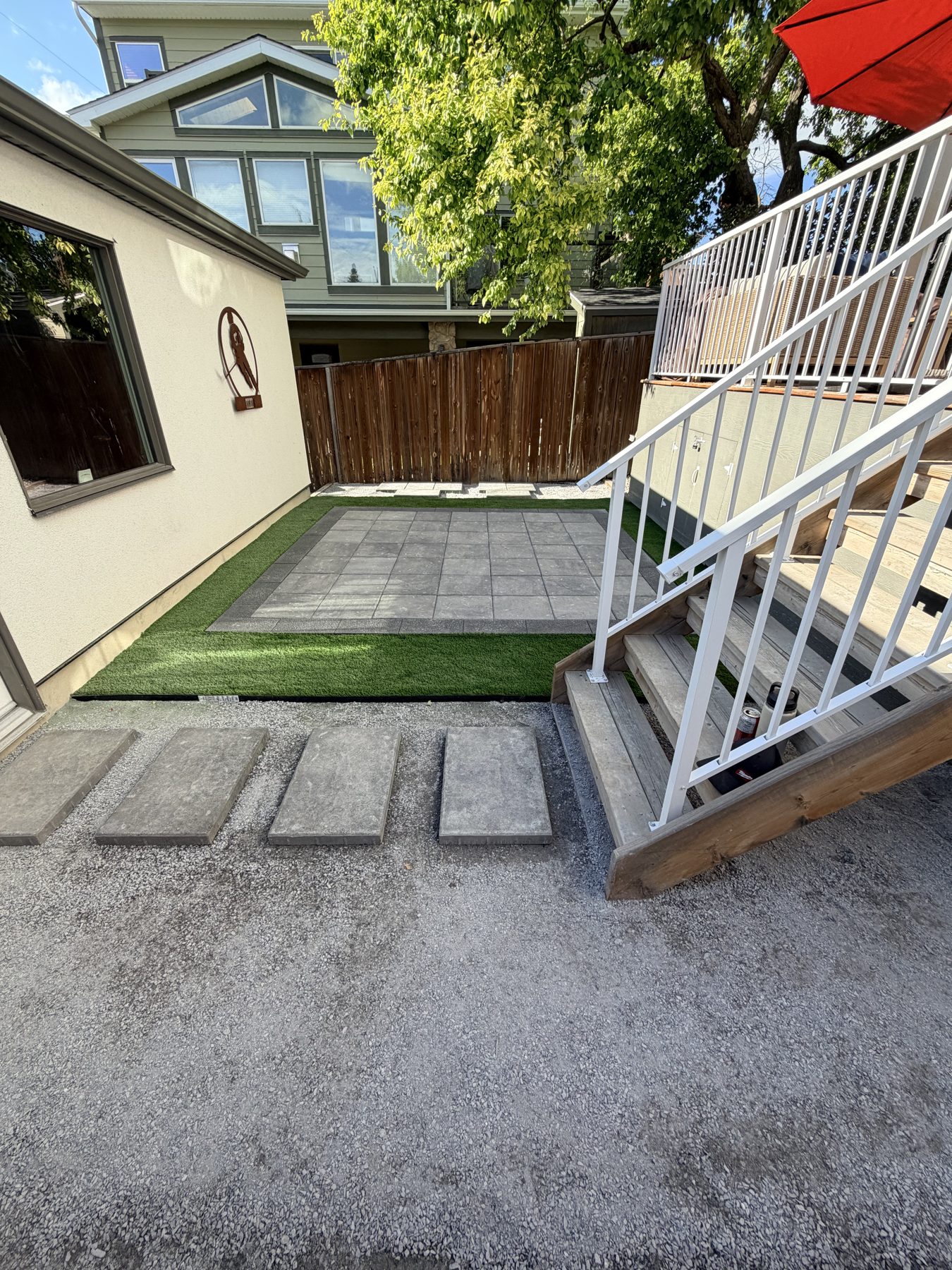 New patio with stone pavers, artificial turf, and gravel pathway — 3505 41 Street SW, Calgary