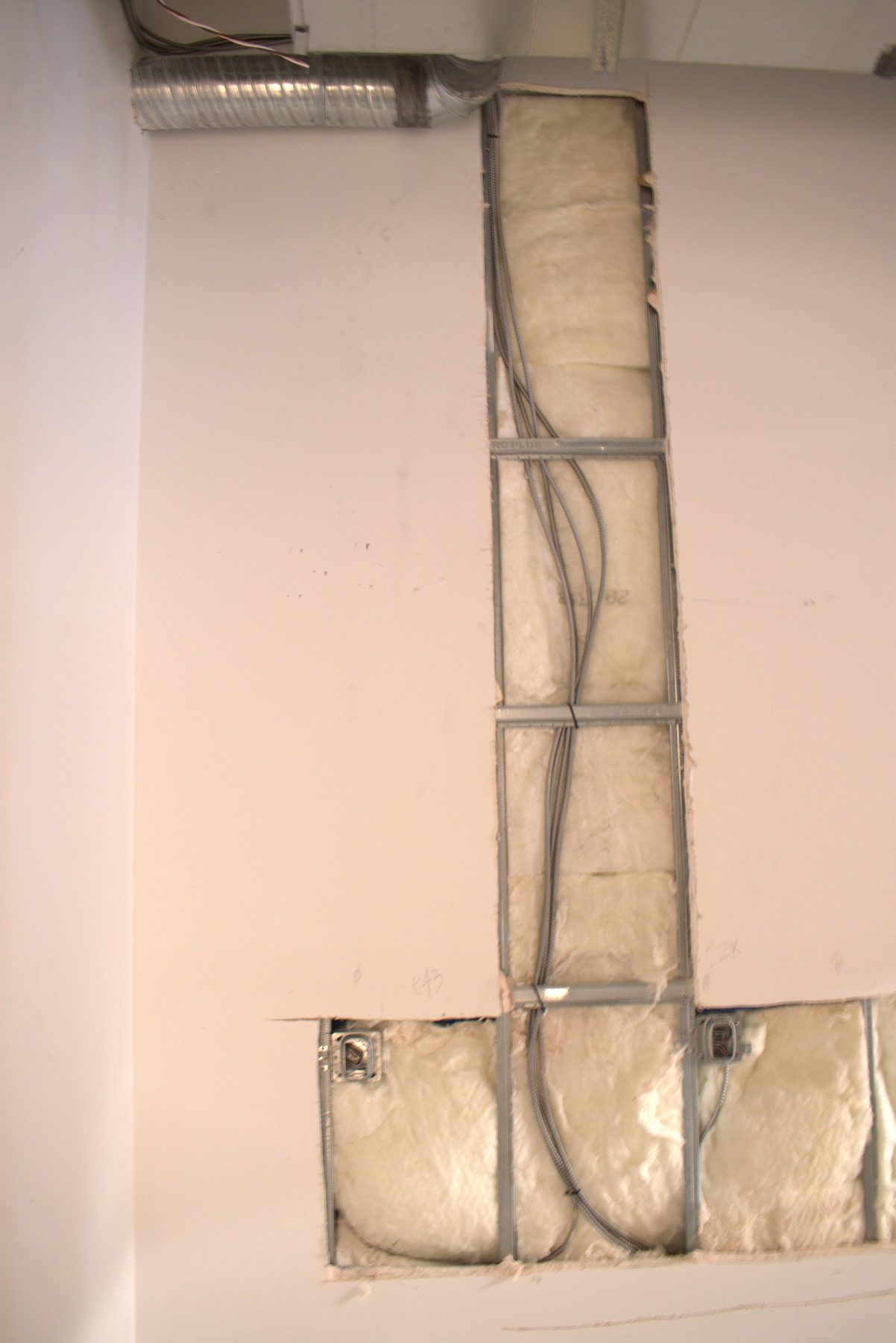 Wall studs, insulation, and electrical conduit during construction phase — Big Buns (Bowness)