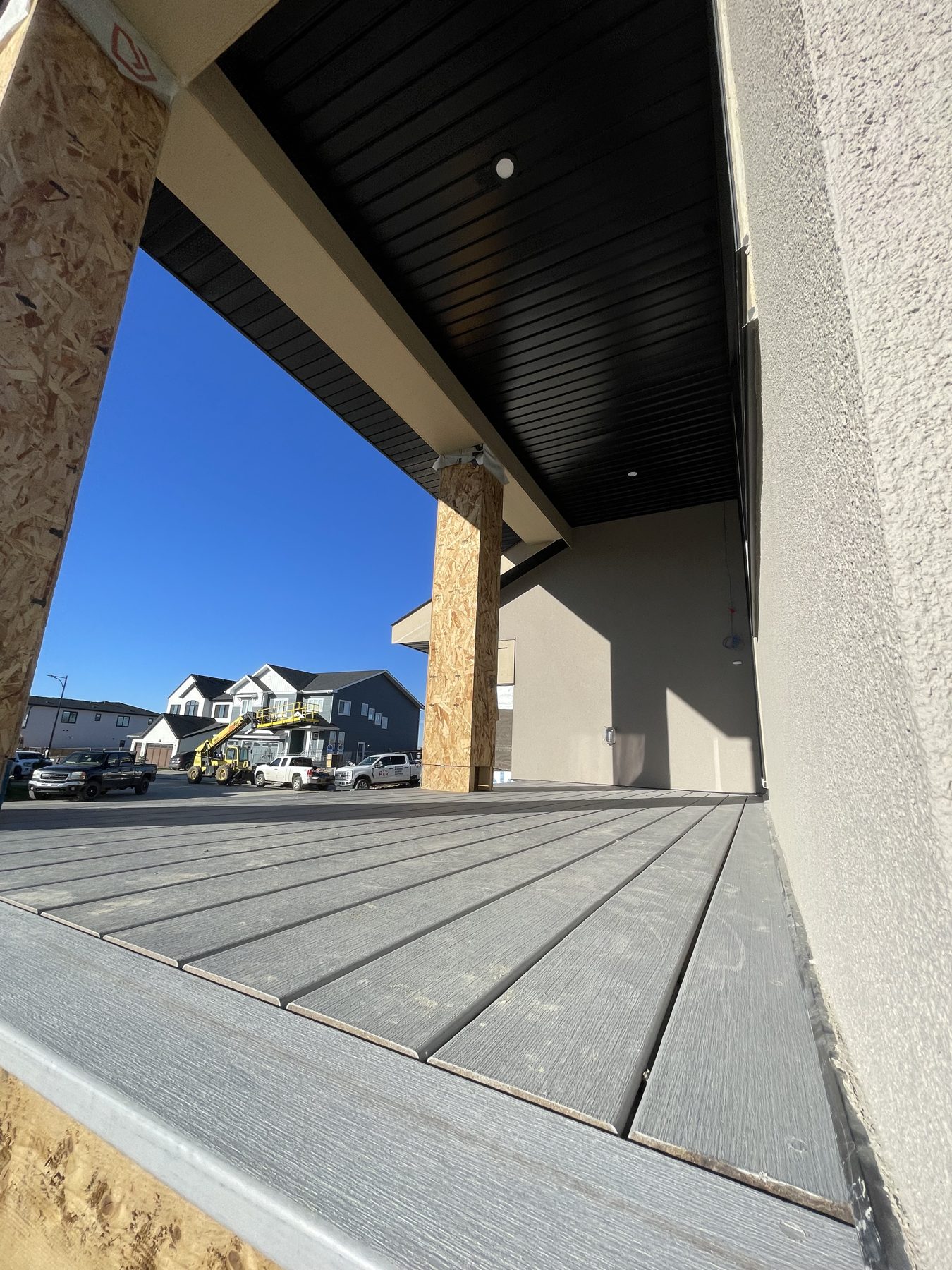 Newly installed gray composite deck with exposed framing and unfinished columns — 96 Fieldstone Close