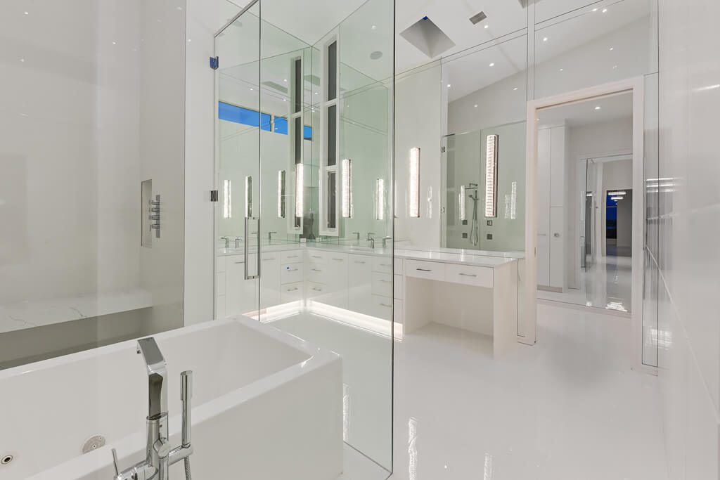 Modern white bathroom with glass shower, soaking tub, and double vanity — Blanc de Blanc
