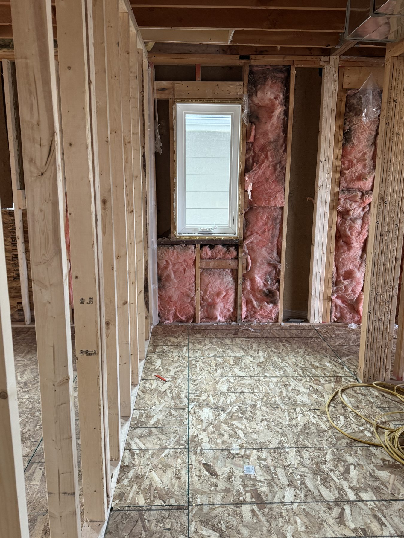 Framing and insulation in room with new window and plywood floor — 188 Lake Adams Crescent SE, Calgary