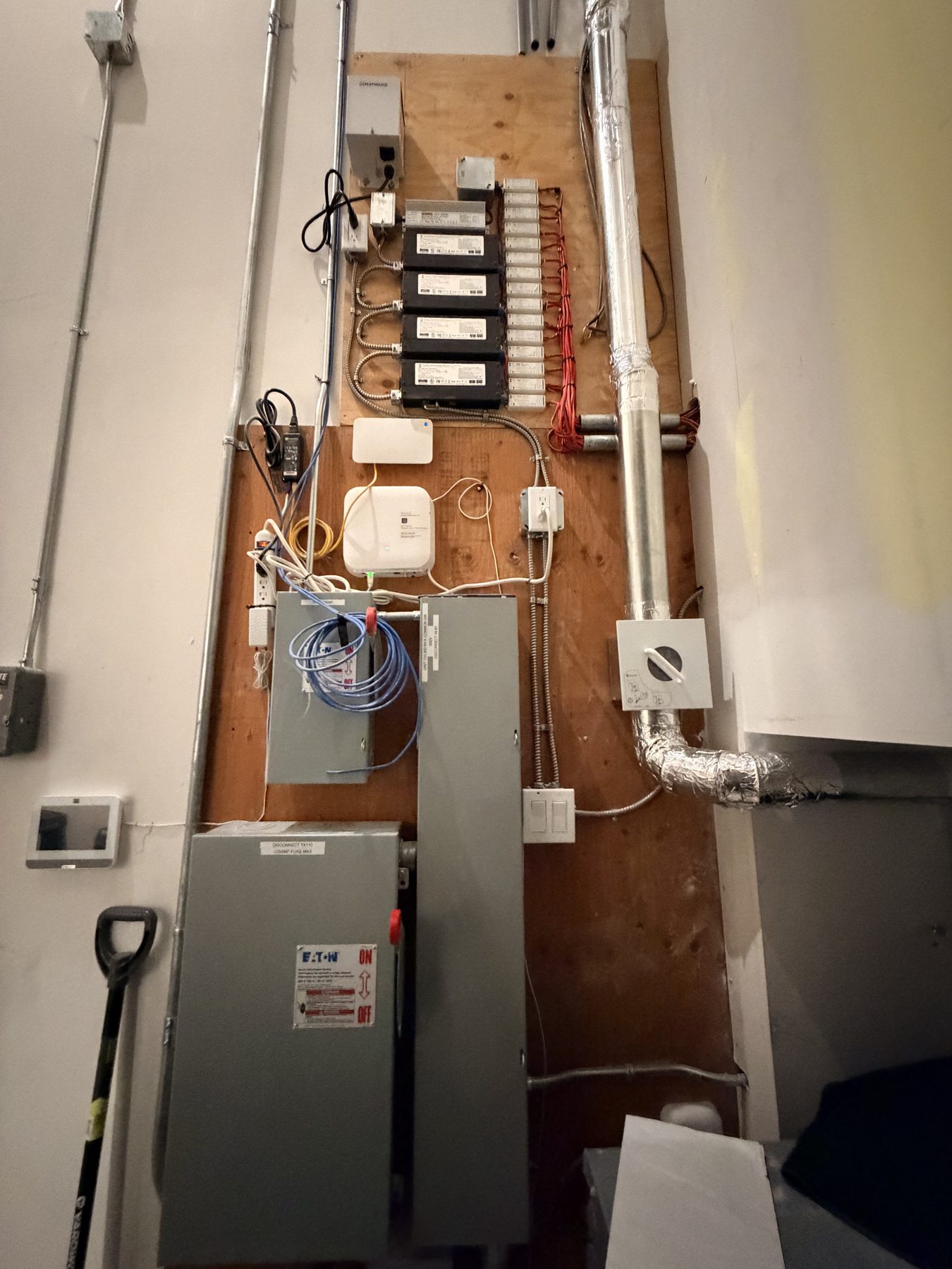 Network equipment, wiring, and ventilation ducts installed on plywood wall — Cedar Steam and Spa (Trinity Hills)