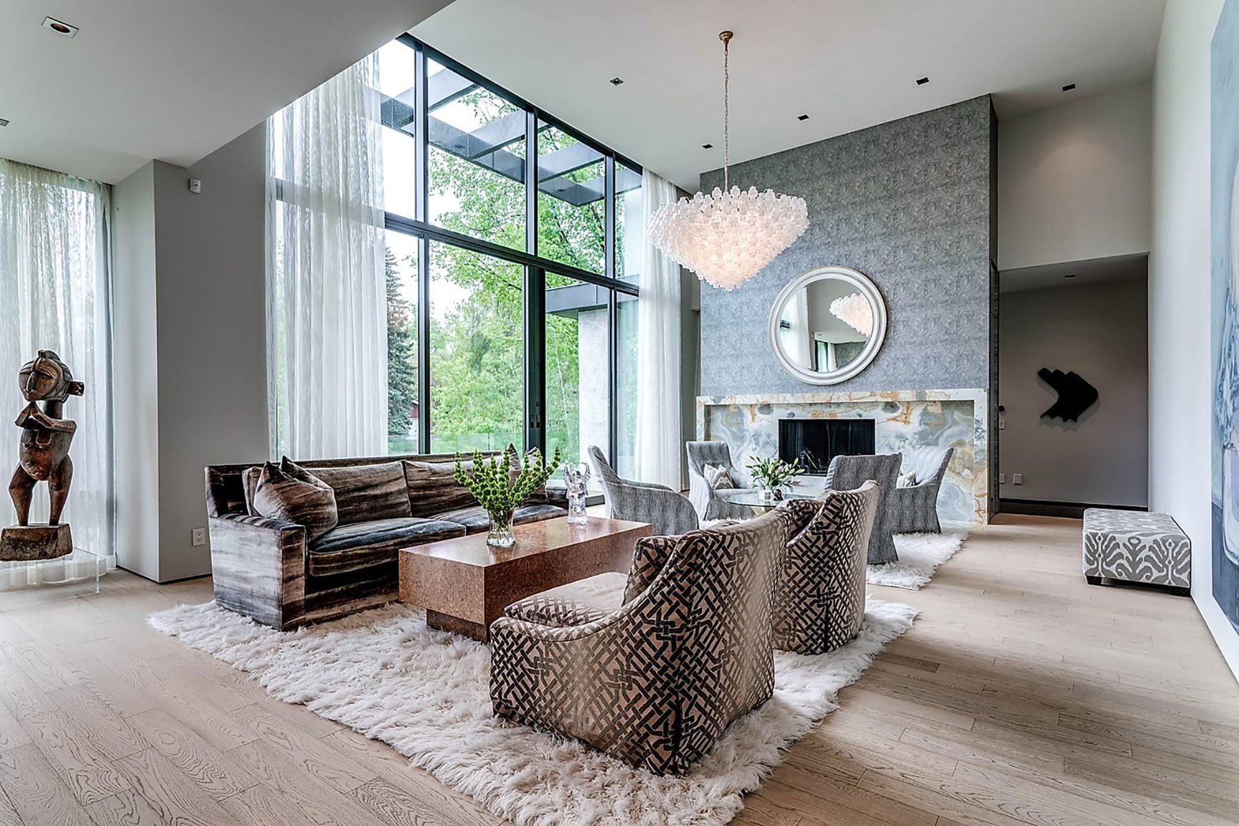 Modern living room with large windows, plush rug, fireplace, and contemporary furniture — Modern Family