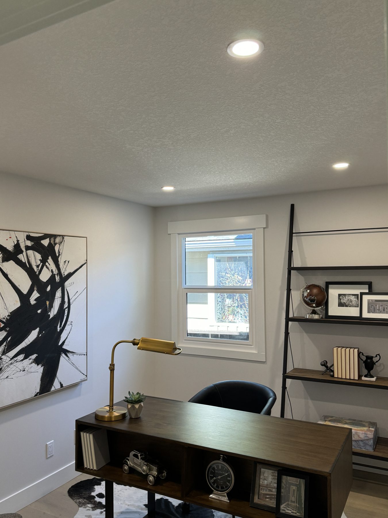 Modern office with dark wood desk, black chair, and artwork — Lake Bonavista