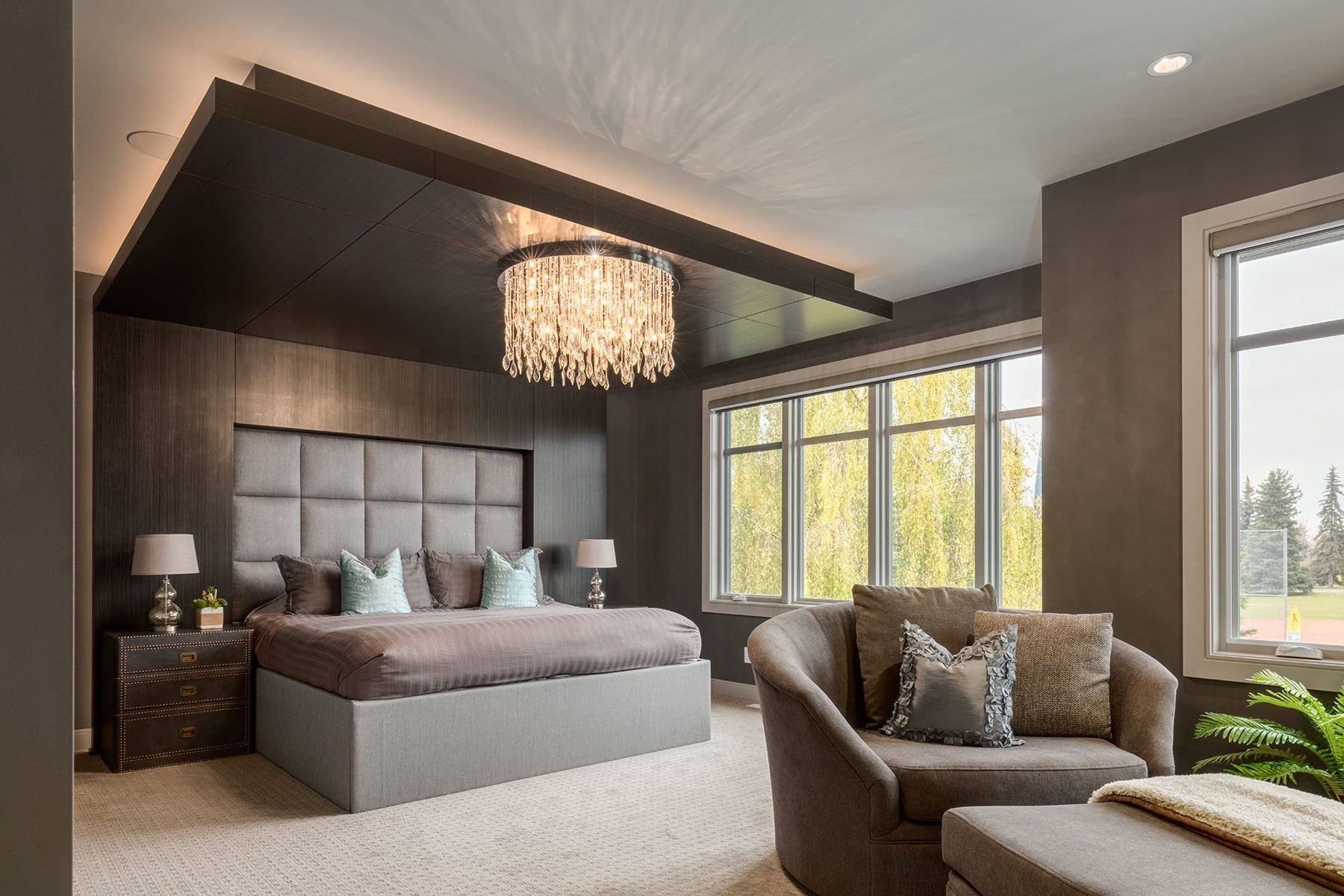 Master bedroom with tufted headboard, chandelier, and large windows — The Cellar