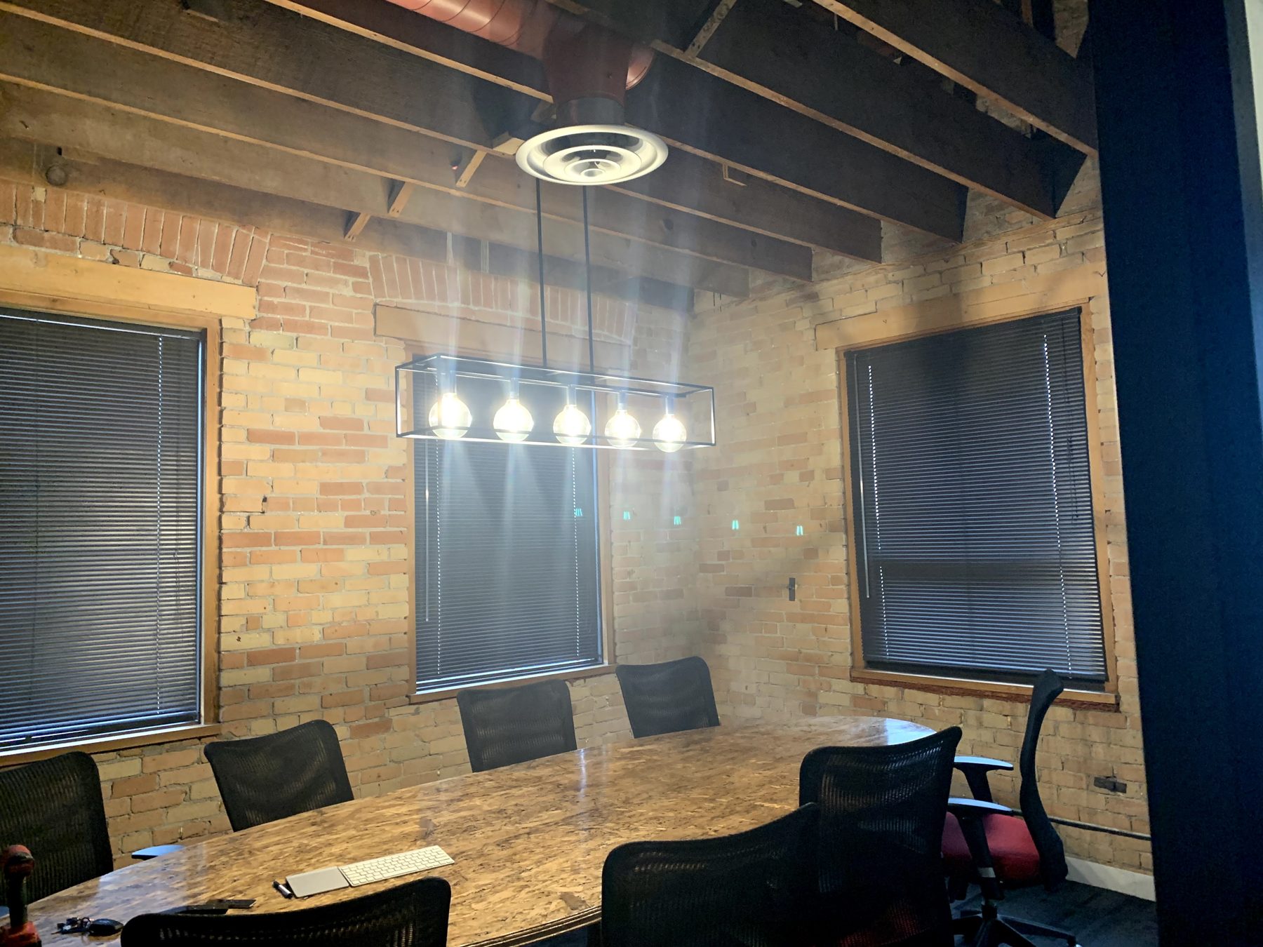 Conference room with exposed brick, beams, and industrial light fixture — Clearmotive (Victoria Park)