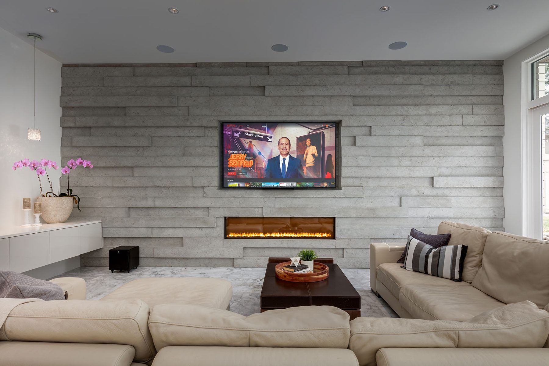 Living room with mounted TV, linear fireplace, and sectional sofa — Germania