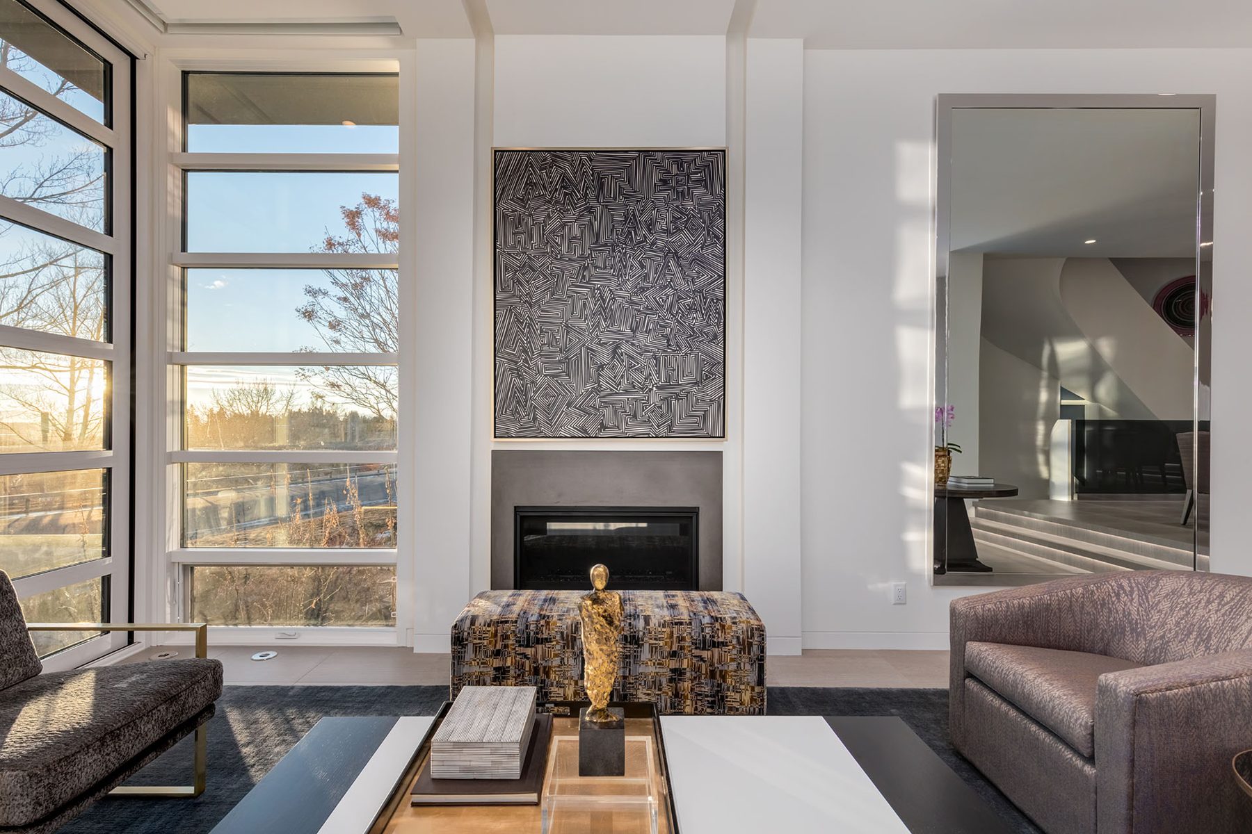 Modern living room with fireplace, art, and mirrored wall — Skyline