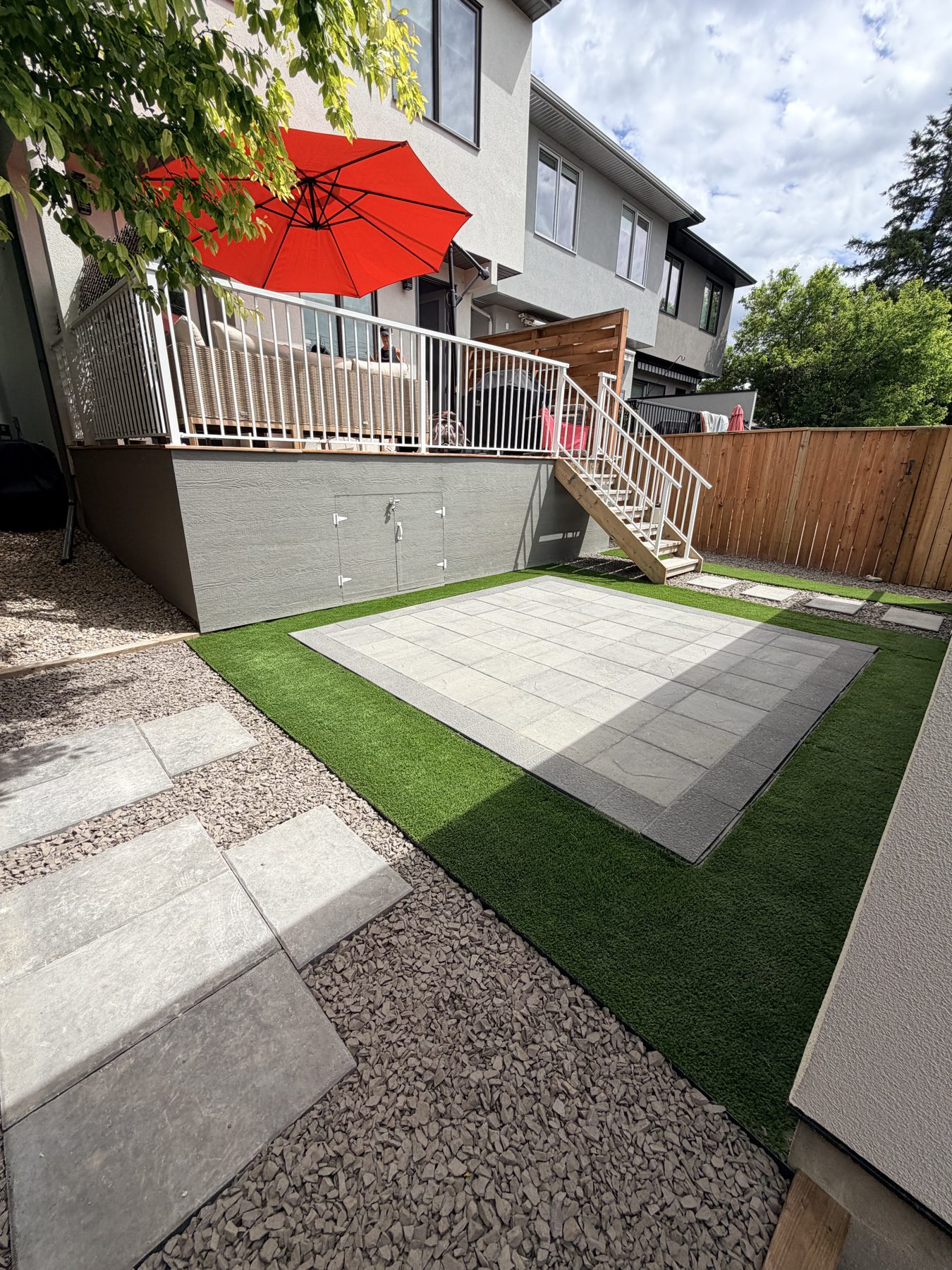 Modern backyard patio with artificial turf, stone pavers, and deck — 3505 41 Street SW, Calgary