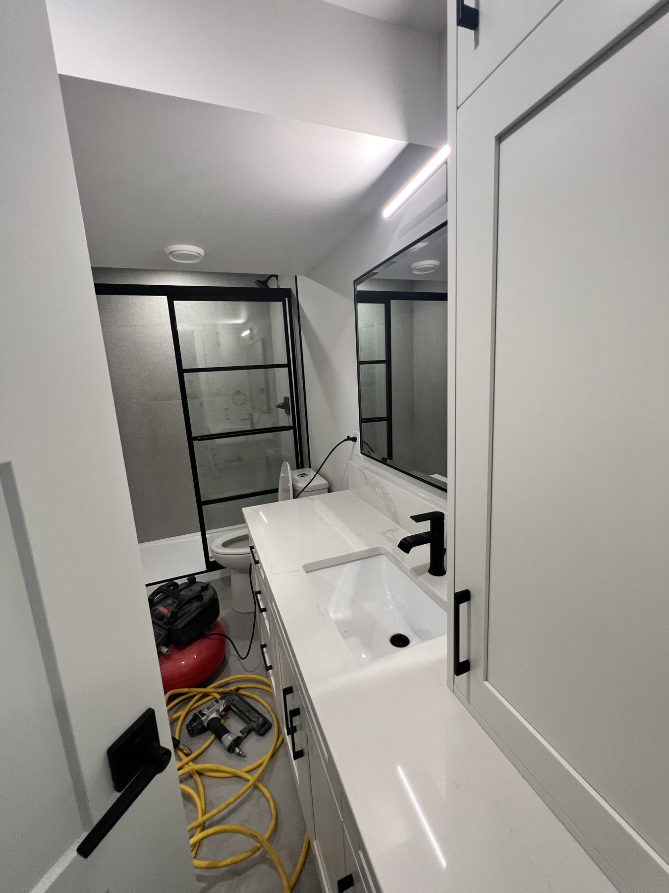 Modern bathroom renovation with black fixtures and new vanity — 720 Lake Twintree Crescent SE, Calgary