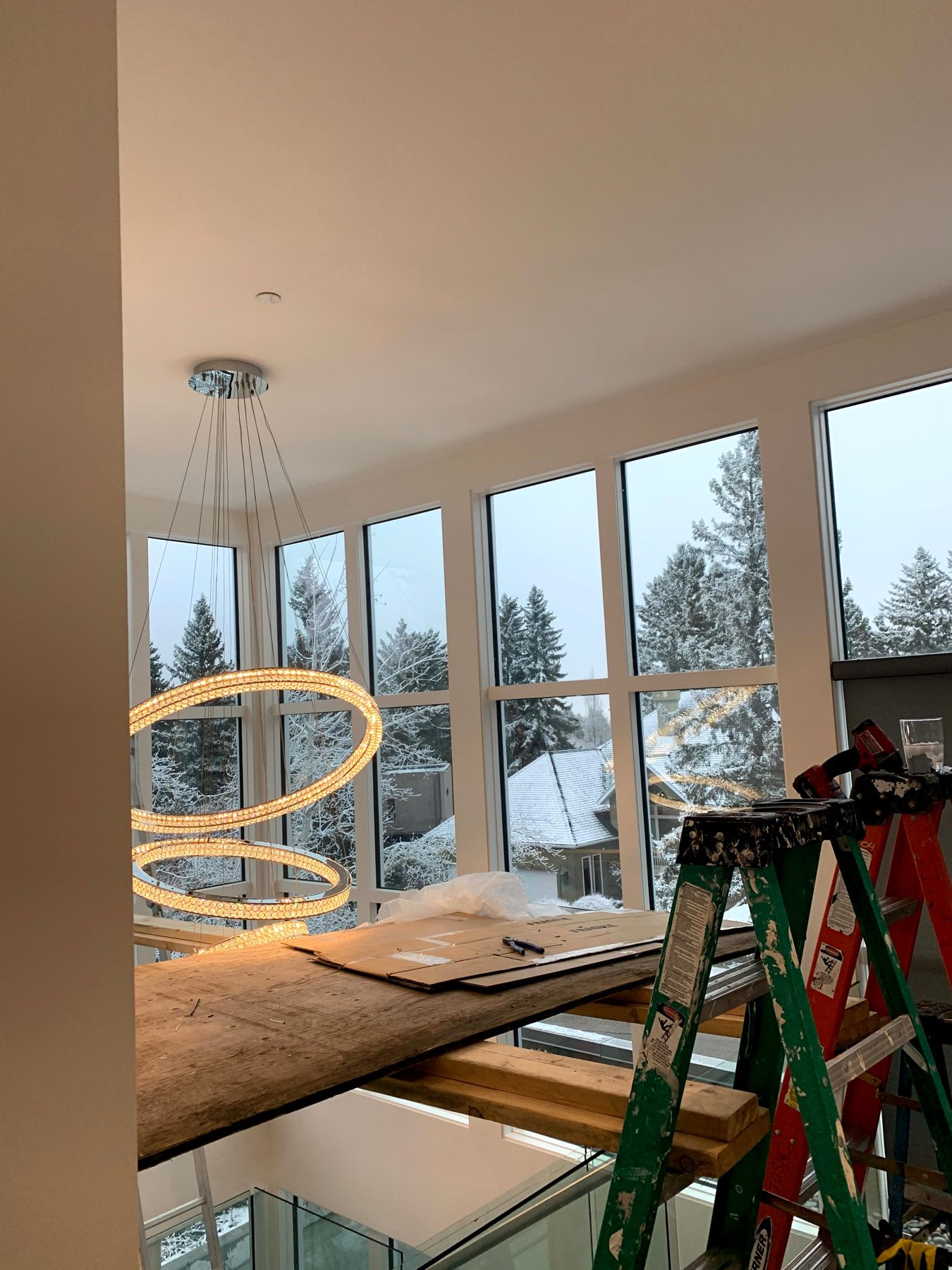 Modern circular chandelier installed in room with large windows — Pump Hill by Onsite Contracting Services