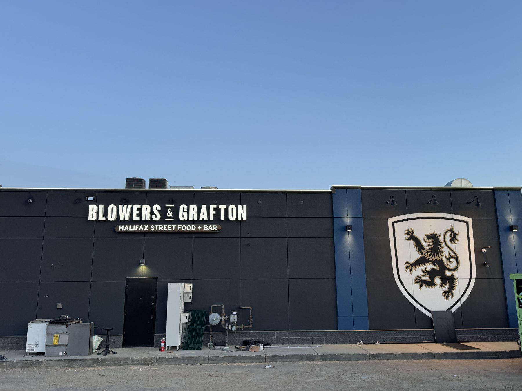 Exterior facade with new signage, HVAC units, and temporary equipment placement — Blowers and Grafton (Lloydminster)