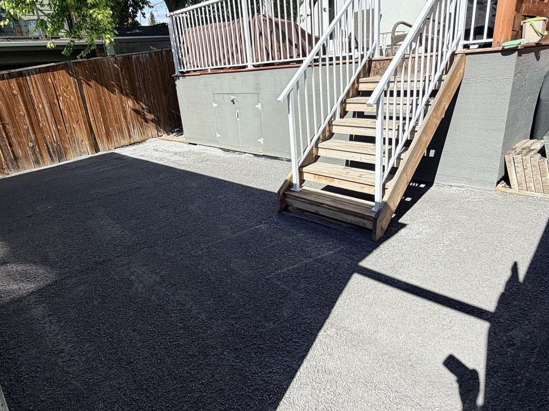 Newly poured asphalt driveway with wooden stairs and white railing — 3505 41 Street SW, Calgary