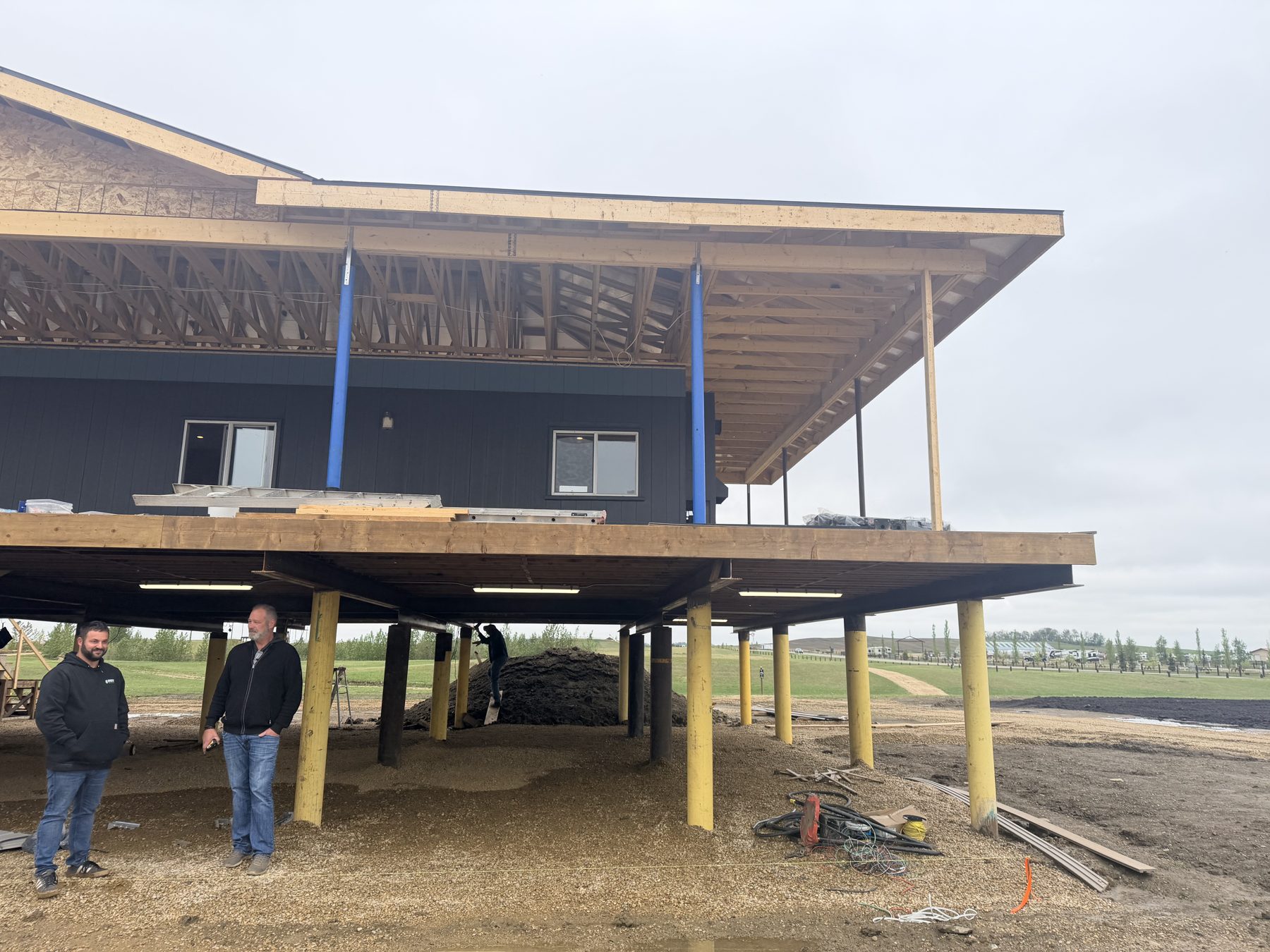 Construction of elevated home with exposed wooden framing and pilings — Sandy Point (Club House)