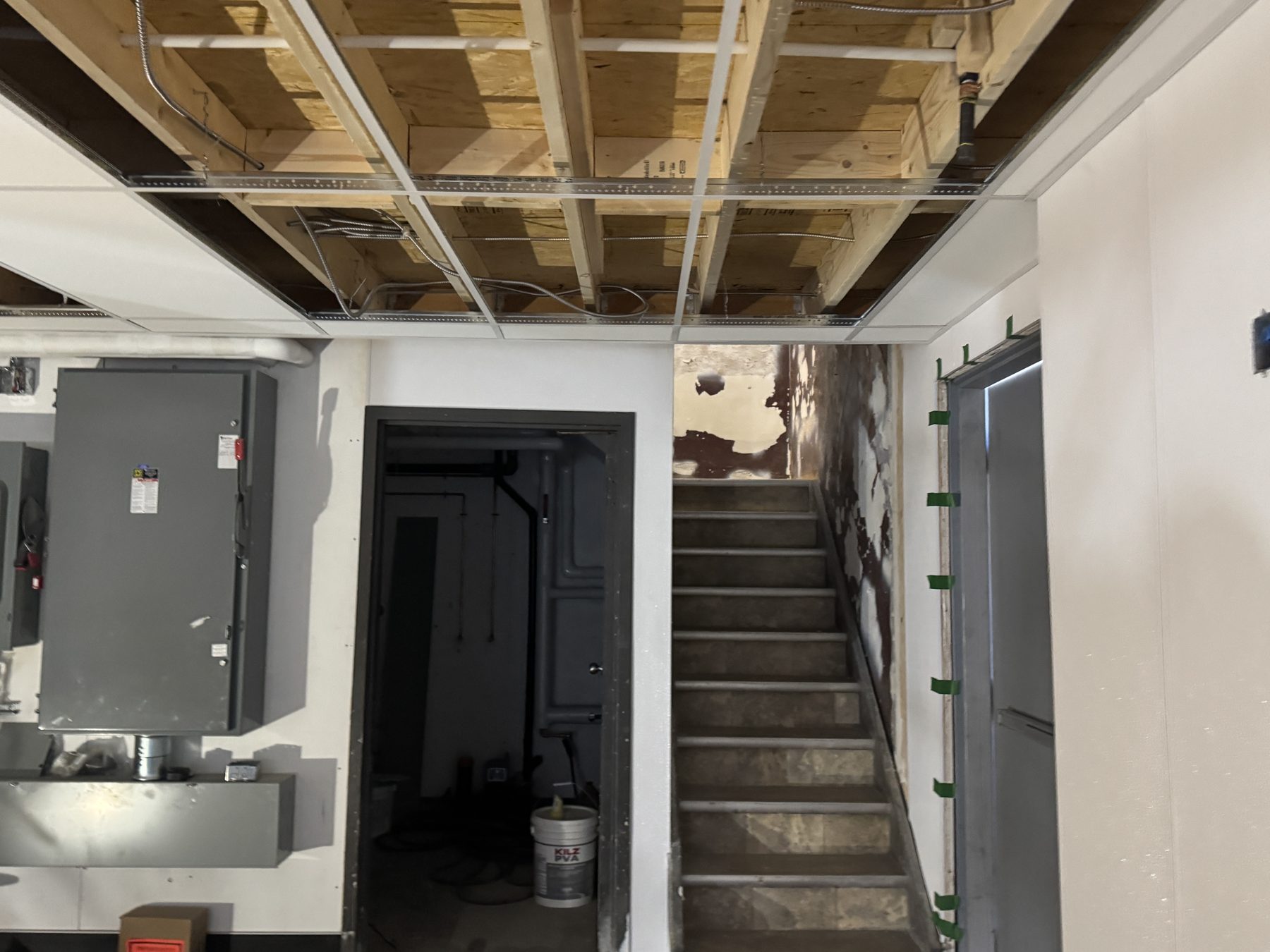 Exposed ceiling joists, HVAC unit, and stairwell during renovation — Blowers and Grafton (Red Deer)