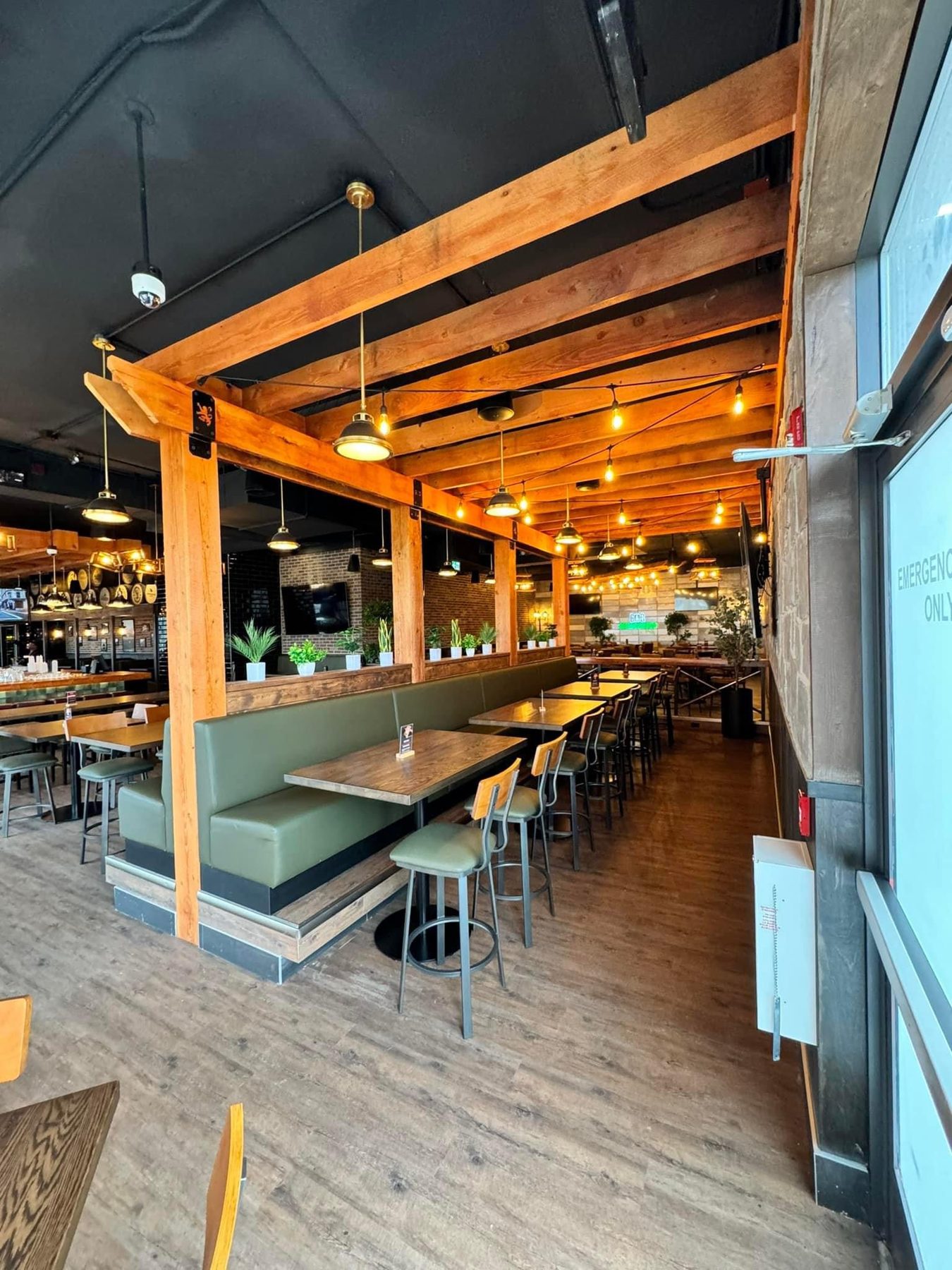 Restaurant dining area with wooden beams, green booths, and pendant lights — Blowers and Grafton (Shawnessy)