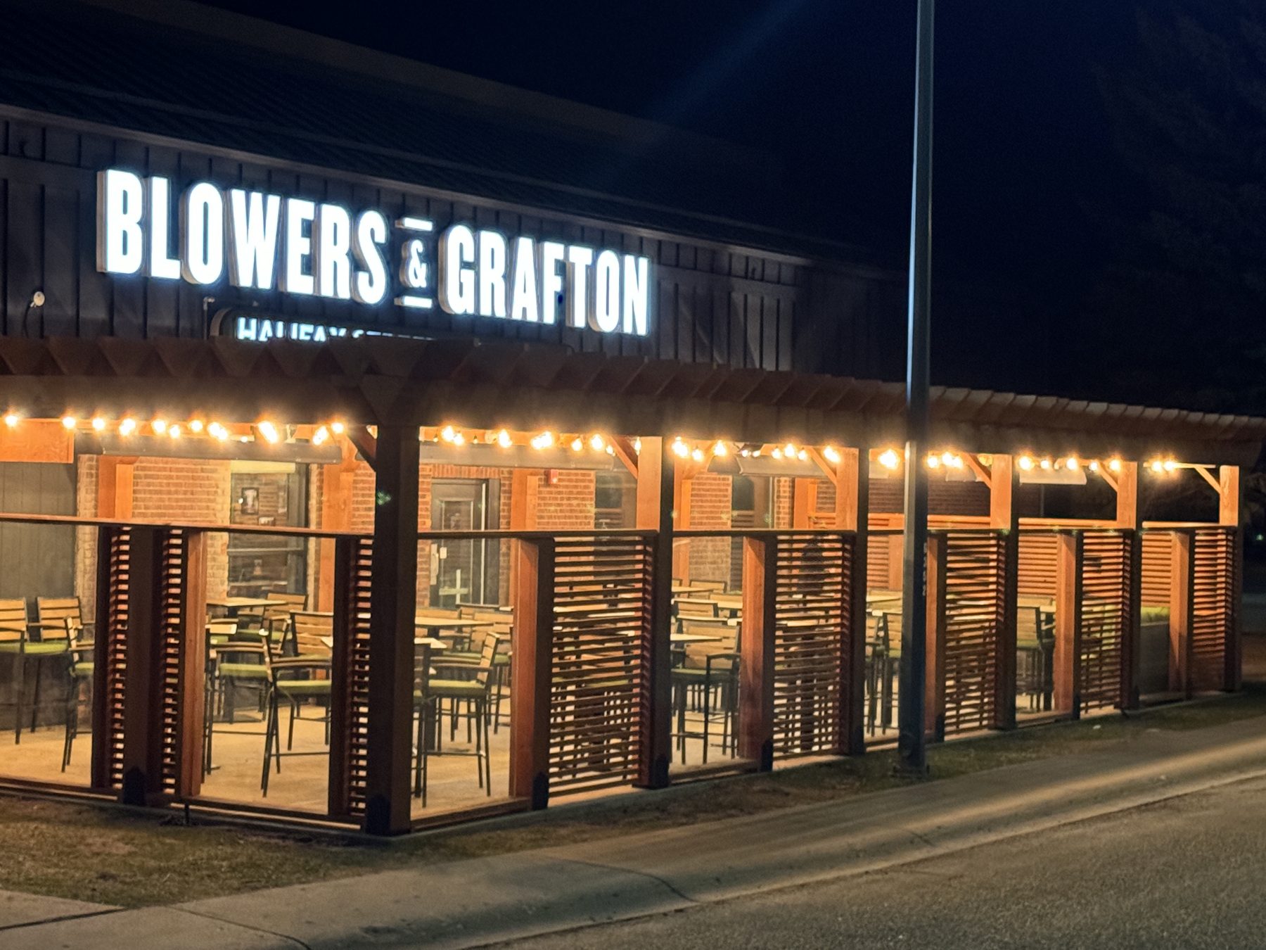 Restaurant patio construction with string lights and wood slatted enclosures — Blowers and Grafton (Medicine Hat)