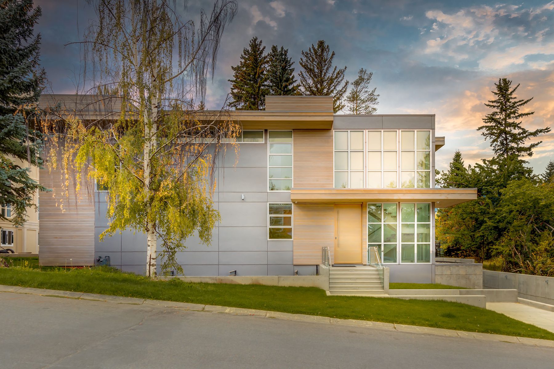 Modern house with wood and gray panels, large windows, and concrete landscaping — Germania by Onsite Contracting Services